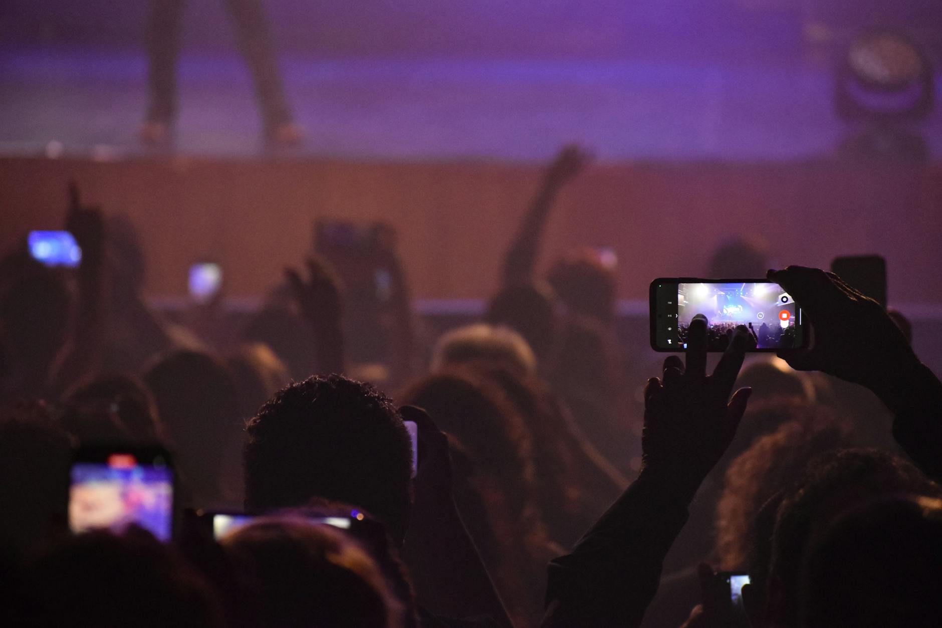 Audience capturing live music performance with phones at night concert in San Luis, Argentina.
